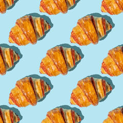 Wall Mural - Seamless pattern with sweet croissant on blue background.