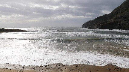 Canvas Print - Spanish beach sea waves at cloudy rainy weather. Cala Reona in Cabo de Palos. Mediterranean Sea landscape, coast in Murcia region. Tourist site. Slow motion