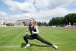 Young fitness woman working out with dumbbells in the city stadium.