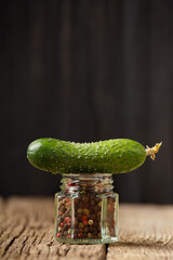 Wall Mural - Fresh cucumber on a jar with spices close-up.