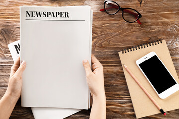 Woman with newspapers on wooden background