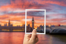 Hand Holding Up An Instant Photo Picture Of The Big Ben In London Great Britain With The Actual Blurred Landscape In The Background