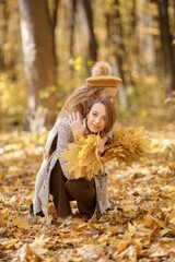 Wall Mural - Mother and her daughter playing and having fun in autumn forest