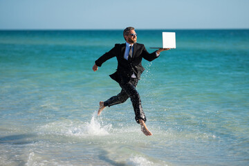 Excited millennial hispanic business man in suit on sea. Summer vacation, business on sea beach. 40s business man on summer business travel. Dream for summer vacations office workers.