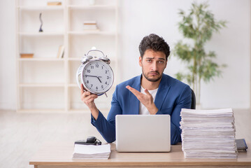 Wall Mural - Young male employee in time management concept