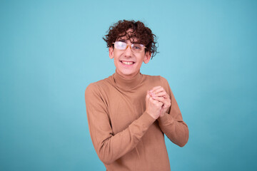 Wall Mural - Emotional guy is surprised, happy and sad posing in the studio on a blue background.