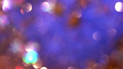 Wall Mural - Abstract colorful Christmas bokeh background. Gold bokeh lights falling on blue background. Glowing golden defocused circles and stars in motion. Natural blurry glitter effect.