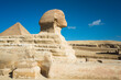 The Great Sphinx profile with the pyramid of Cheops or Khufu in the background in Giza, Egypt, Blue sky little cloud, no people