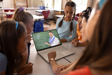 Poster - Multiracial teacher and students studying mathematics online over video call on laptop in classroom