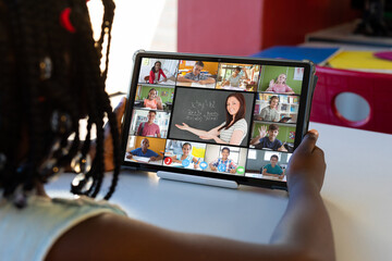 Poster - African american girl looking at teacher and students on digital tablet screen during online class