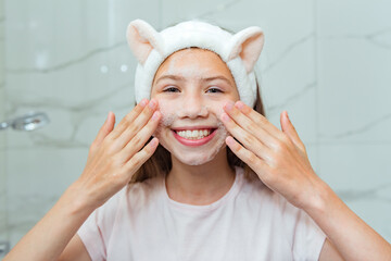 teen girl face wash exfoliation scrub soap with skincare cleansing. portrait beautiful female smile 