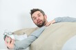 © auremar - stunned man in bed holding alarm clock