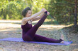 © Olja Reka - Young woman doing yoga outdoors in the park