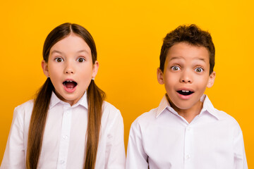 Photo of cute impressed preteen schoolchildren wear white shirts open mouth isolated yellow color background