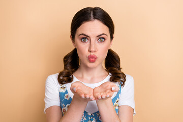 Sticker - Photo of cheerful positive adorable girl with curly ponytails wear blue overall send kiss to you isolated on pastel color background