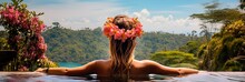 Woman With Flowers In Hair Relaxing In Infinity Pool With A View To The Jungle.