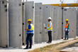 © NVB Stocker - african american architect Engineering man and asian worker in safety hardhat working at precast factory industrial. Heavy Industry Manufacturing Factory. Prefabricated concrete walls