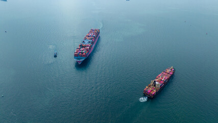 Aerial in front view of Two 2 Large Cargo Ship carrying container and running in Opposite direction for export import Cargo at sea sunset ocean concept technology transportation logistics