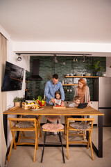 Wall Mural - Young family preparing vegetables in the kitchen