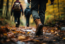 Group Of Tourists Walks Along The Path Of The Autumn Forest. Traveling In A Small Group. Feet Close-up.