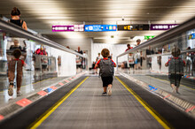 Little Traveler In Airport Walking On Moving Walkway Without Parents