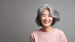 © Robert Kneschke - East Asian woman in 60s, short gray hair, rose background