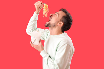 Poster - Handsome man eating Chinese noodles on red background