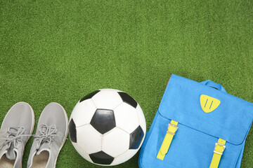 Wall Mural - Sneakers with backpack and soccer ball on color background