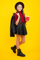 Poster - Teenage girl with take away cup of cappuccino coffee or tea. Child with takeaway cup on yellow background, morning drink beverage. Happy teenager portrait. Smiling girl.