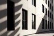 buildings' shadows. Sunlight-infused abstract architecture background with light, black window shadow overlay, and white texture wall. design presentations, stationary, wall art, posters, and mockups.