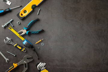 Recognizing the valuable work of construction workers on Labor Day. Top-down image showcasing various construction instruments on grunge textured grey concrete. Copyspace for ads or text