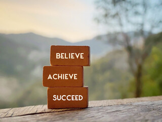 Wall Mural - Confidence Inspirational quote. Believe achieve succeed text on stack of bricks.