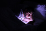 Fototapeta Zwierzęta - Man using smartphone in bed at night. Internet addiction