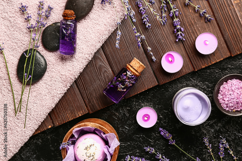 Composition with cosmetic products, spa accessories and lavender flowers on dark background
