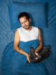 © Narayan - latin man playing in bed with his friend dog, sleep concept