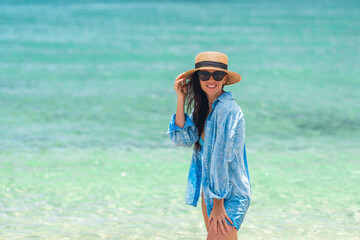 Wall Mural - Young happy woman on the beach enjoy her summer vacation. Girl is happy and calm in her stay on the beach