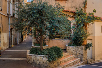  Narrow road between traditional old houses on a street near the local covered provencal farmers market in old town or Vieil Antibes, South of France