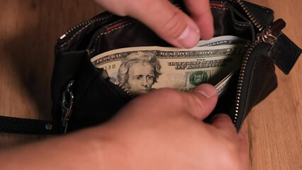 Wall Mural - Man unzips wallet with money and gives twenty dollar bill woman hand, paying for purchase in store, wooden table. Rational distribution of budget in family.