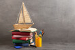 Education is a journey concept, toy boat and books on the table, inspiration for a writing a fairy tale. Elementary school supplies