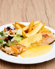 Canvas Print - Salmon steak with fries, salad and hollandaise sauce