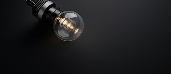 Poster - Photo of a close up of a luminous light bulb against a dark backdrop with copy space