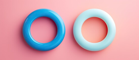 Photo of pink and blue rings on a vibrant pink background with plenty of copy space with copy space