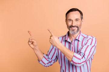 Poster - Portrait of satisfied toothy beaming person with beard striped shirt directing at promo empty space isolated on pastel color background