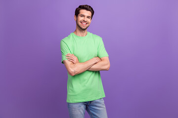 Sticker - Photo of pleasant positive toothy beaming man with stubble green t-shirt standing arms crossed isolated on purple color background