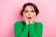 © deagreez - Portrait of terrified confused woman staring touch cheeks wear green shirt speechless shocked stupor isolated on pink color background