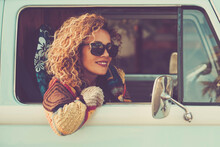 Travel With Classic Vehicle. One Hapy Tourist Pportrait Enjoying Destination Outside The Window Of Blue Classic Van. Curly Beautiful Woman Traveler Lifestyle. Alternative Life And Freedom. Summer