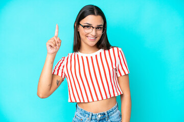 Wall Mural - Young caucasian woman isolated on blue background pointing up a great idea