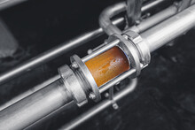 Brewing Equipment For Quality Control, Sight Glass Full Of Golden Beer On Stainless Steel Pipe. Concept Brewery Industry
