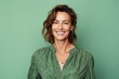 © igolaizola - Portrait of a smiling woman looking at camera isolated over green background