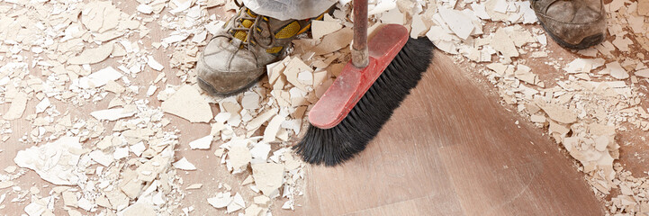 Builder sweeping the floor after renovation